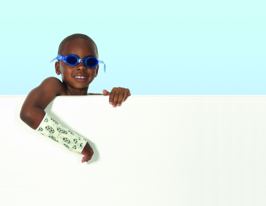 Junge mit Schwimmbrille und Gips am Arm